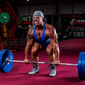 Christian Williams performing an intense deadlift with a heavy barbell in a gym setting.