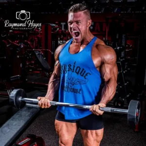 Christian Williams performing an intense barbell curl, showcasing the power of muscle hypertrophy and the ultimate bodybuilding pump